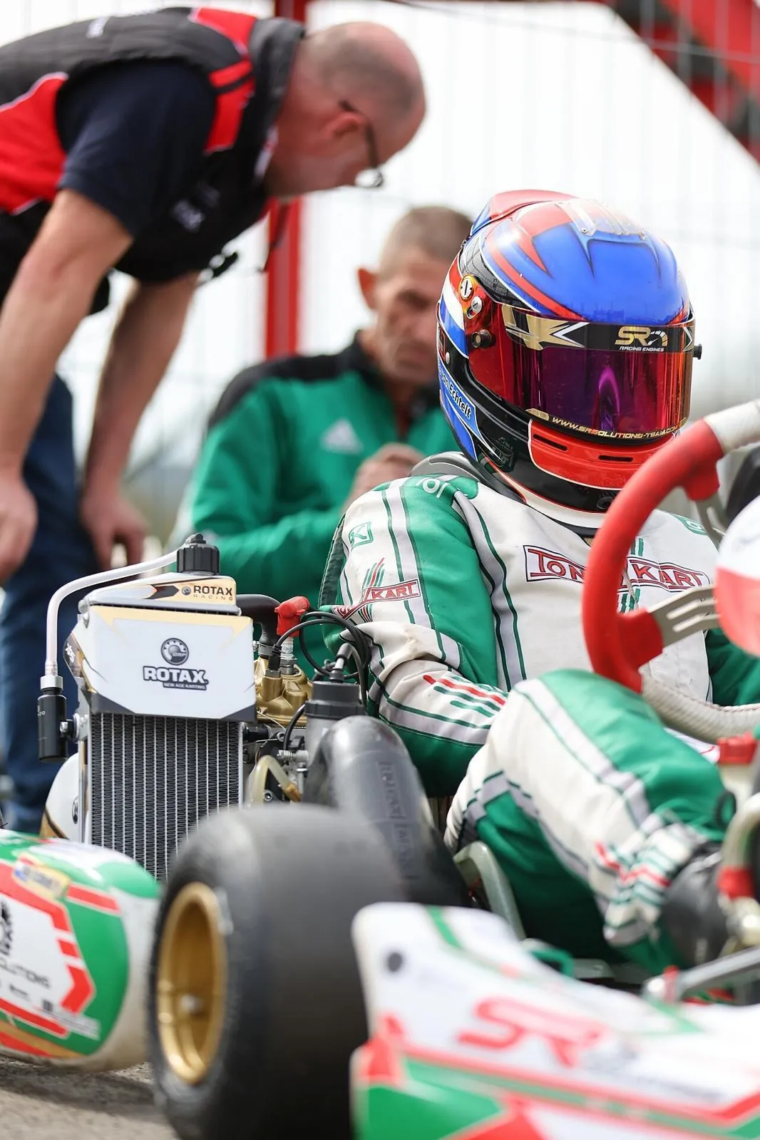 Mechanic and driver preparing a kart